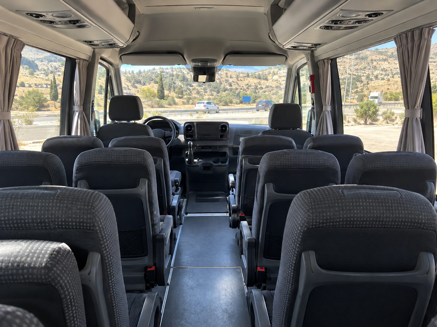 Inside the 21-seat minibus: reclining seats, curtains and roof air-conditioning